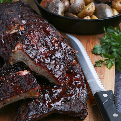 smoked baby back ribs on cutting board served with potatoes