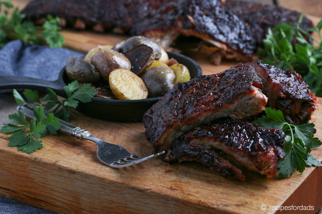 Smoked ribs served with potatoes in iron skillet