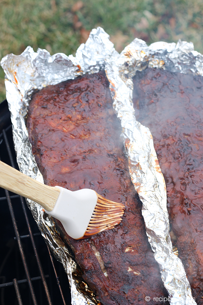 Smothering smoked ribs with BBQ sauce