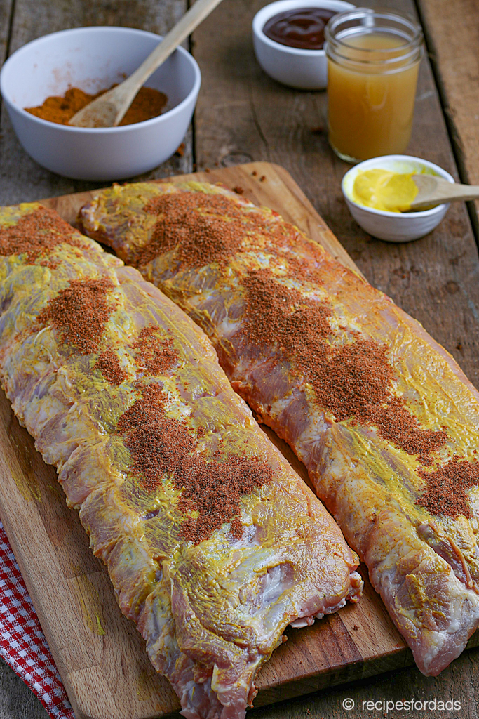 smothering the smoked baby back ribs with mustard and rub