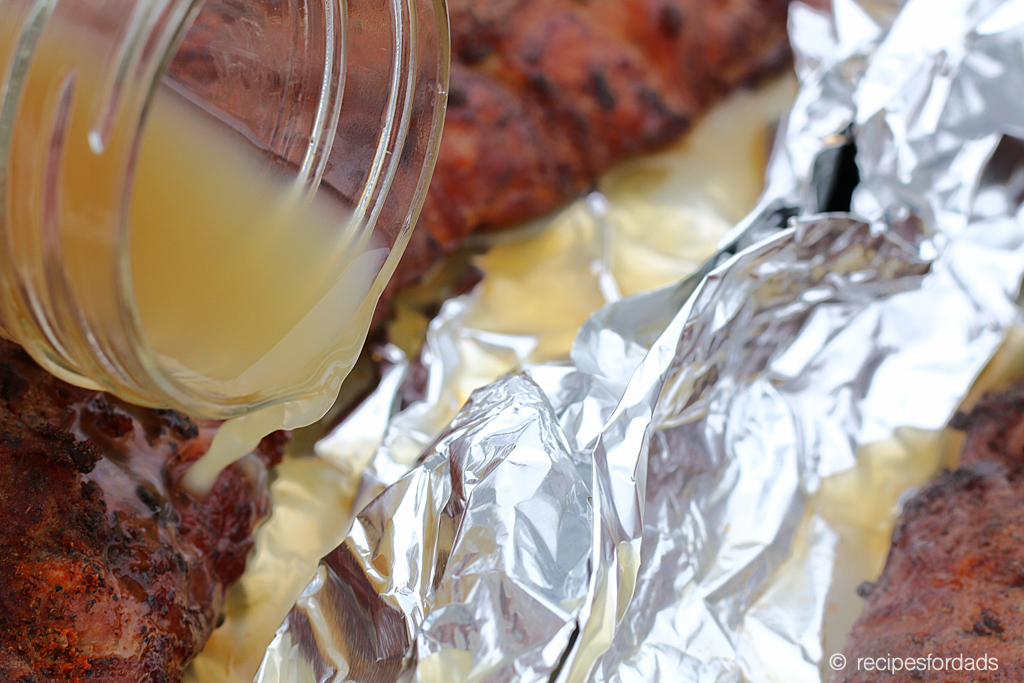 Apple cider being poured on ribs