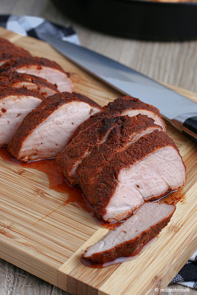sliced smoked pork tenderloin served on cutting board