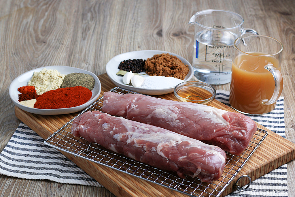 seasonings (rubs) and uncooked pork tenderloin displayed on cutting board