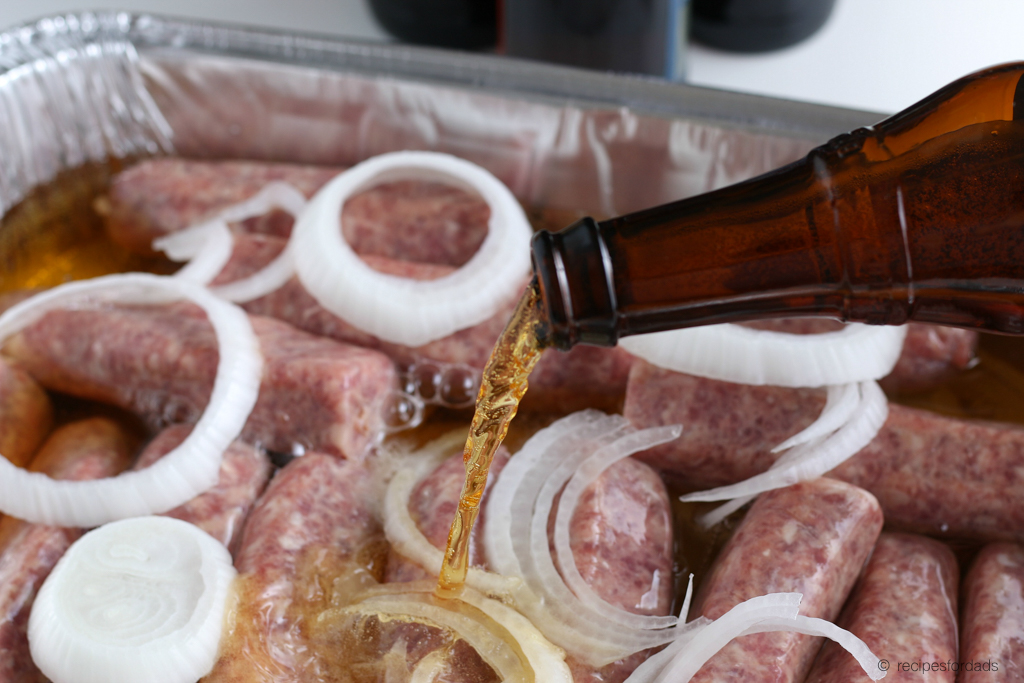 Pouring beer over the uncooked brats with onions