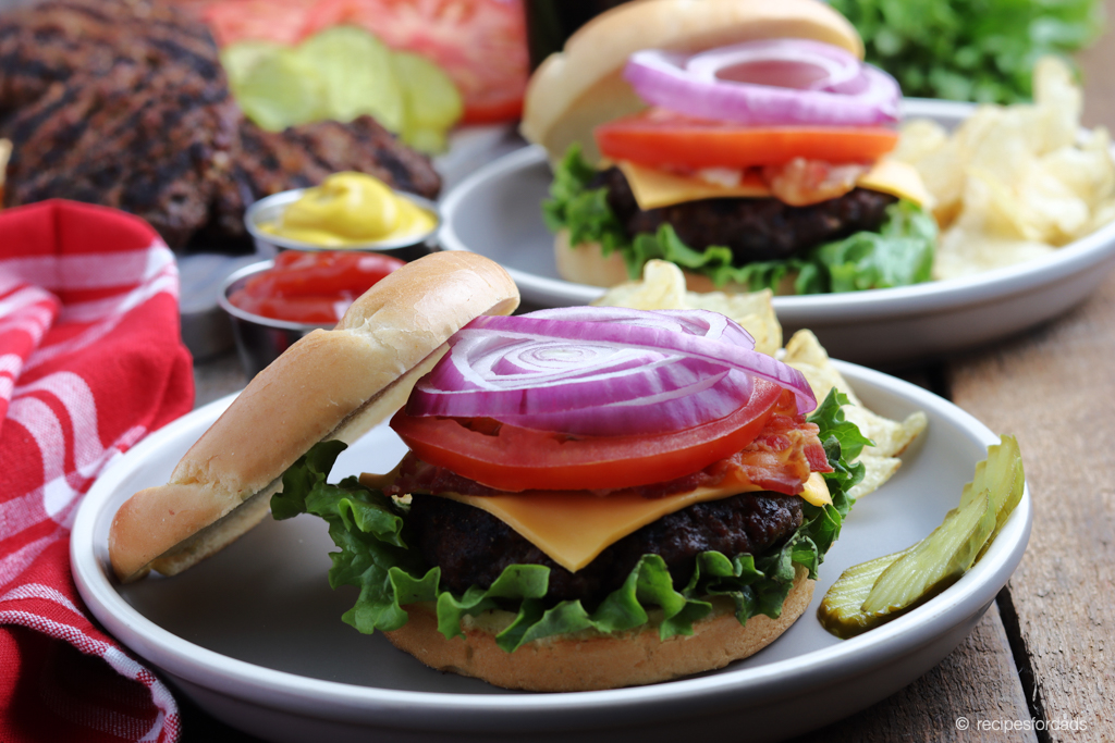 Grilled Burgers topped with lettuce, tomatoes, onion and cheese