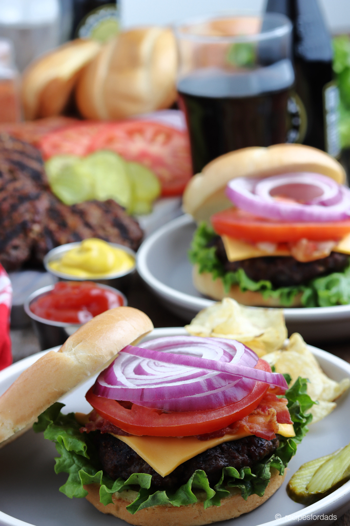 Grilled Burgers topped with lettuce, tomatoes, onion and cheese