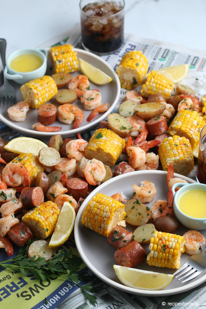 Shrimp boil made with corn, potatoes and sausage, and served with butter and lemons