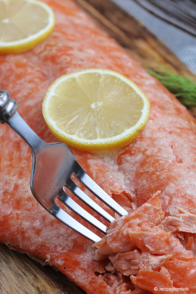 Fork cutting into flavorful and tender smoked salmon 