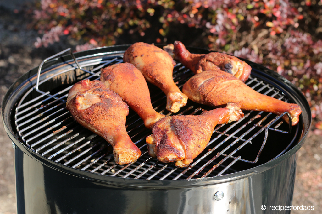 six turkey legs smoking on a Weber smoker