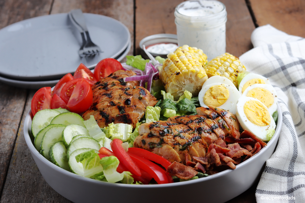 delicious grilled chicken cobb salad served with corn on the cob and boiled eggs (in a gray serving bowl)