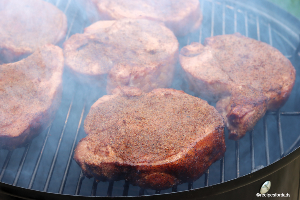 pork chops smoking on a weber smokey mountain smoker