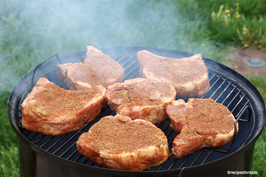 pork chops smoking on a weber smokey mountain smoker