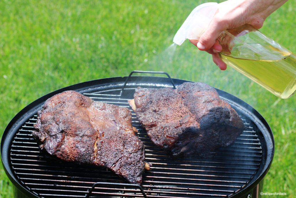 Smoked beef ribs on the Weber Smoker, Vinegar water spritz on ribs to keep moist