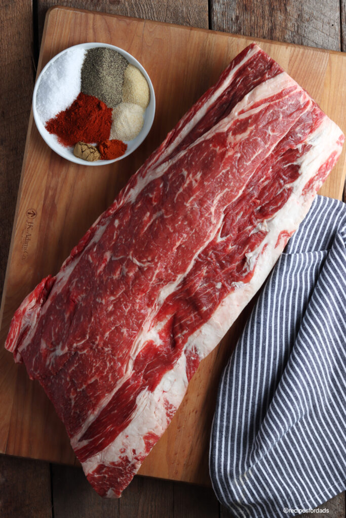 raw ribs served on cutting board and black and white striped napkin