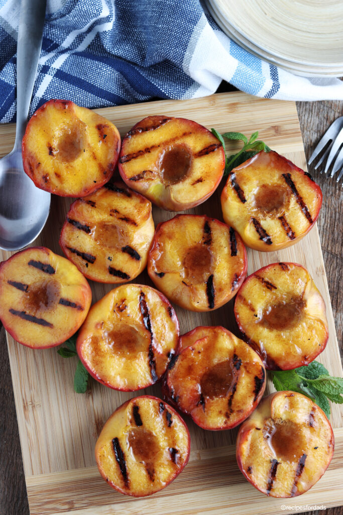 grilled peaches served on cutting board and blue napkin