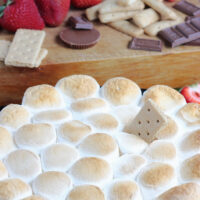 s'mores dip served with strawberries and graham crackers
