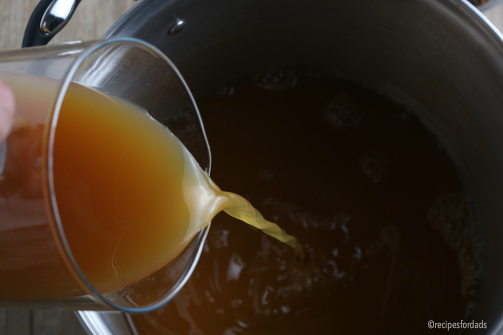 Pouring apple cider into the turkey brine mix