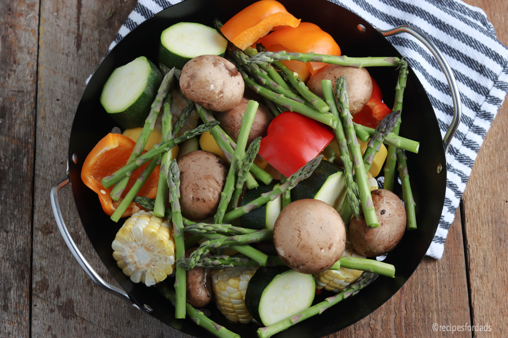 mixed vegetables zucchini, squash, asparagus and corn on the cob in a pan