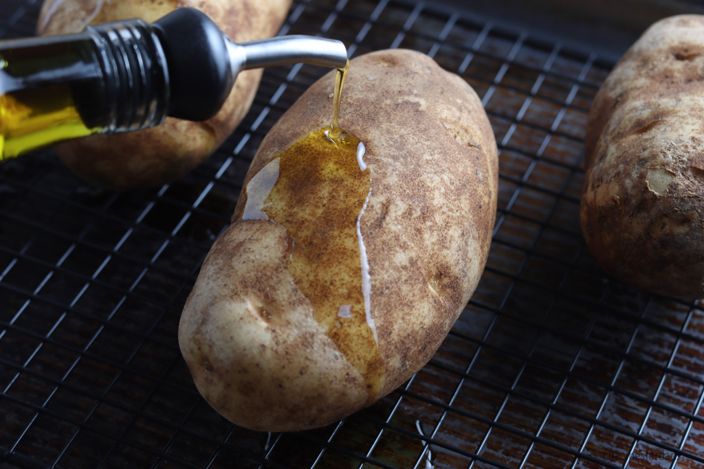 drizzle olive oil over baked potatoes