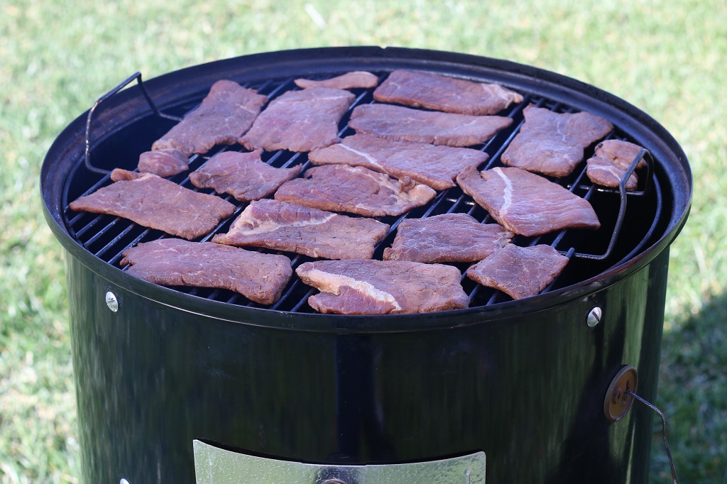 Sliced beef strips on Weber smoker