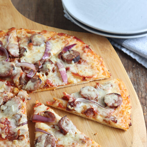 smoked pizza with sausage and bacon served on a pizza pan