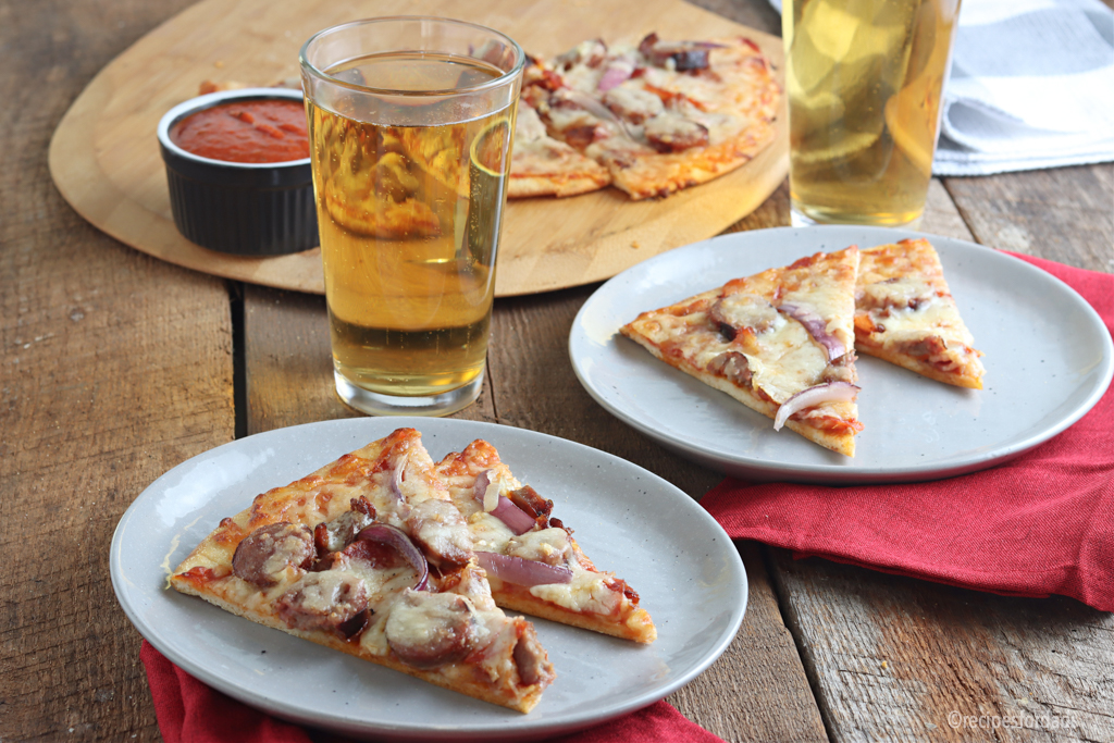 slices of pizza and beer served on white plate