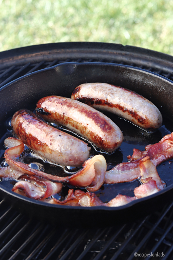 smoking sausage and bacon in iron skillet
