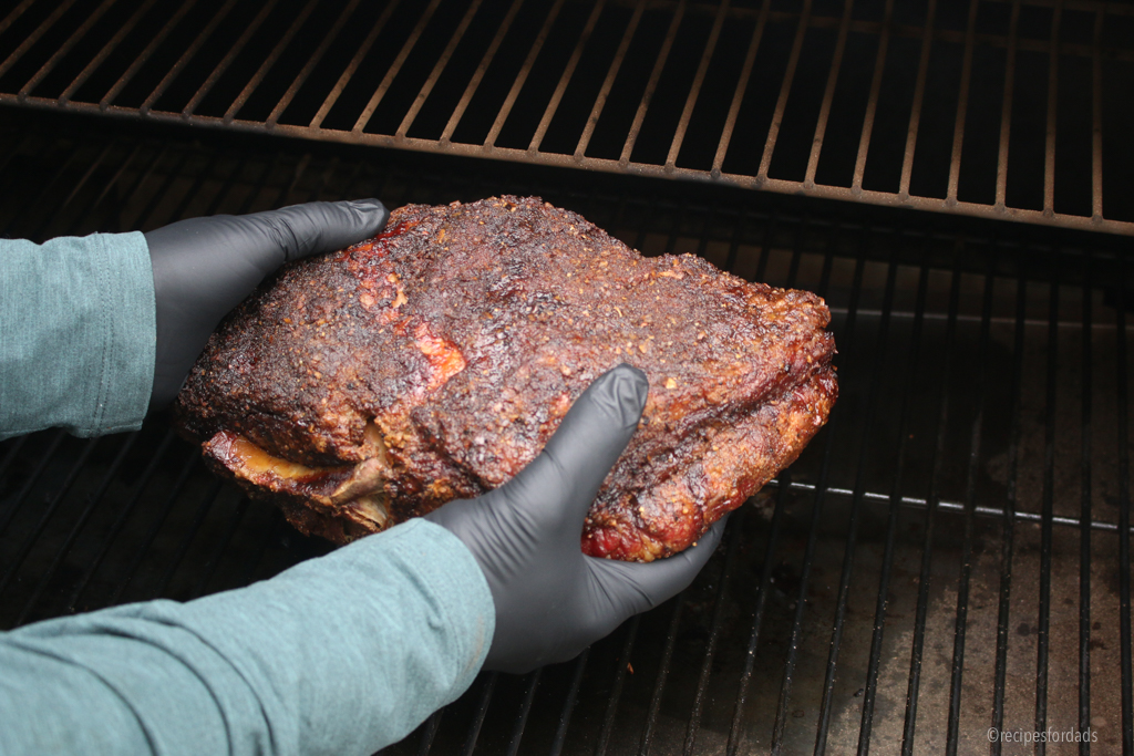 Removing pork butt from Traeger smoker.