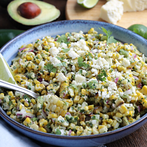 mexican street corn salad with lime served in grey bowl