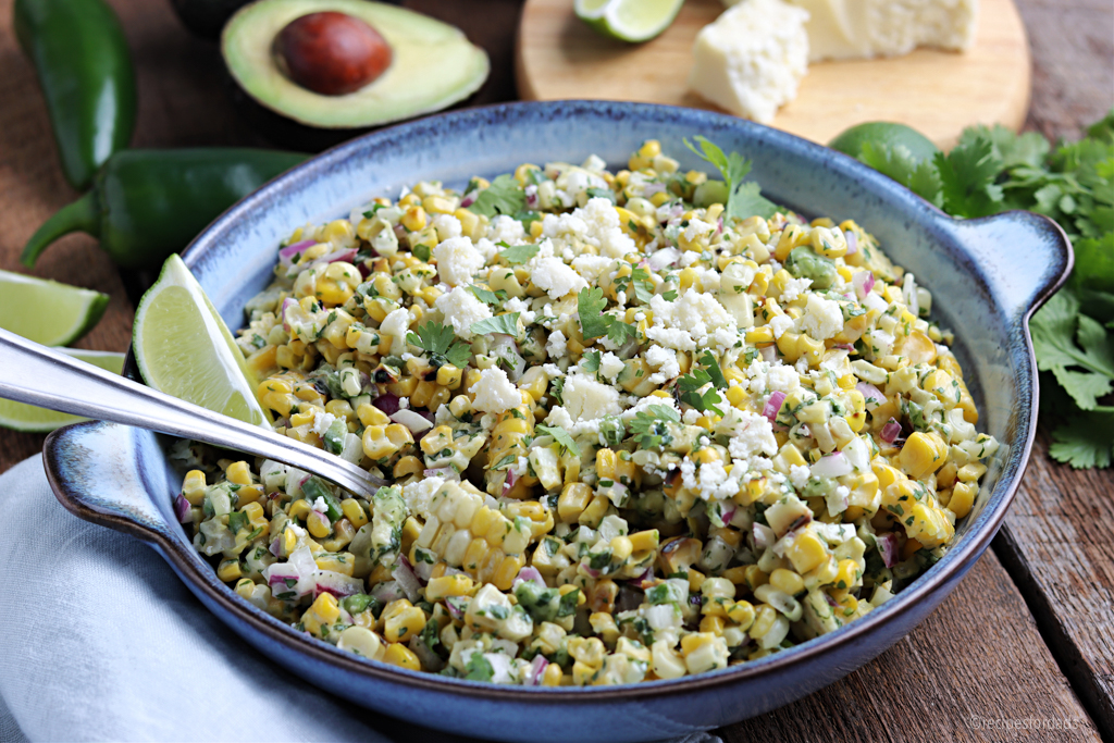 mexican street corn salad with lime served in grey bowl