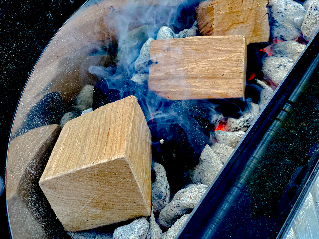 wood chunks burning over charcoal