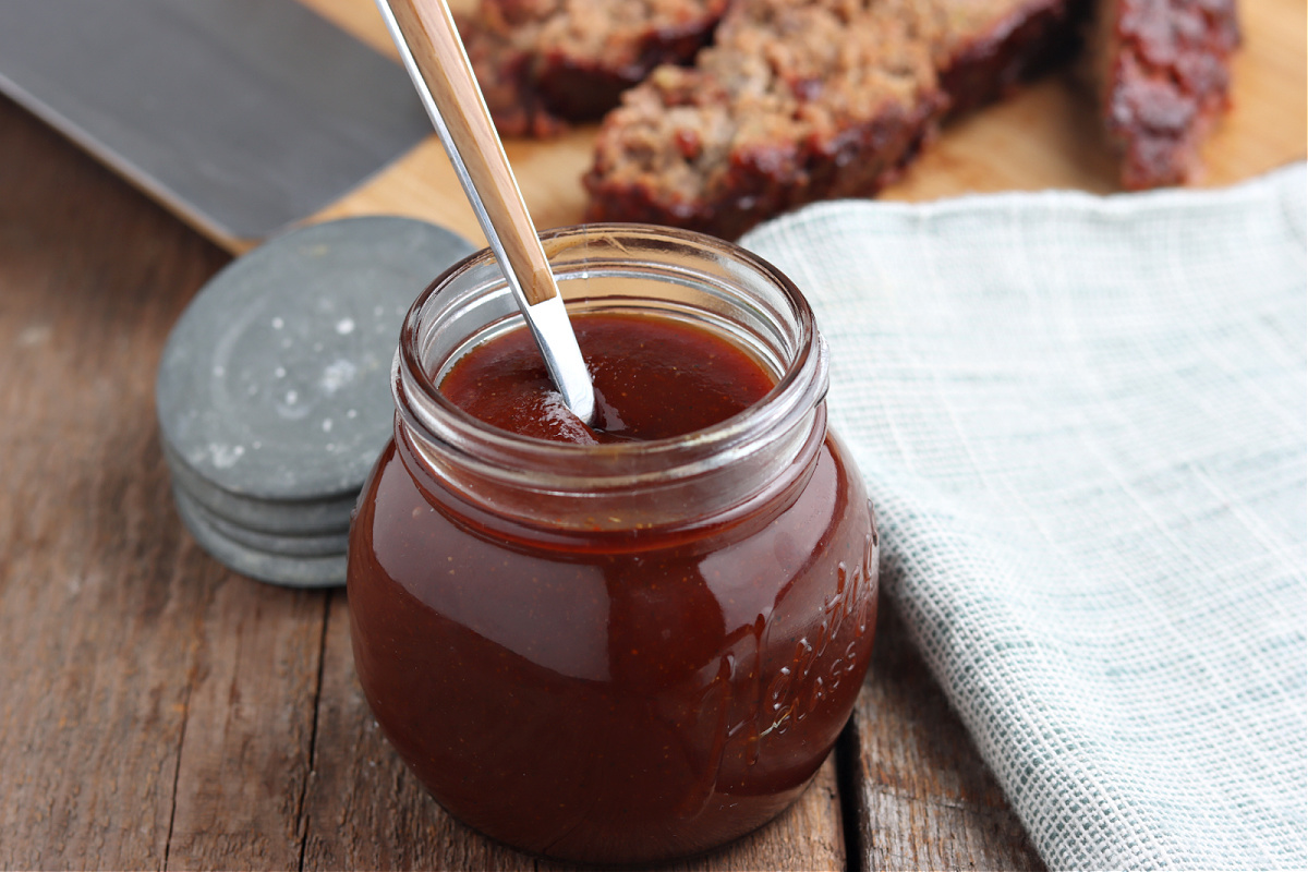 kansas city BBQ sauce in glass jar with meatloaf on board