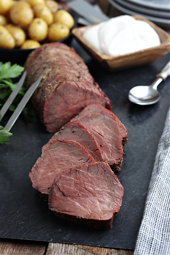 smoked beef tenderloin sliced and served on board