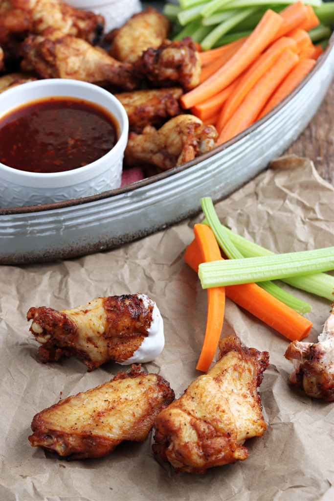 smoked chicken wings with sauce on brown paper