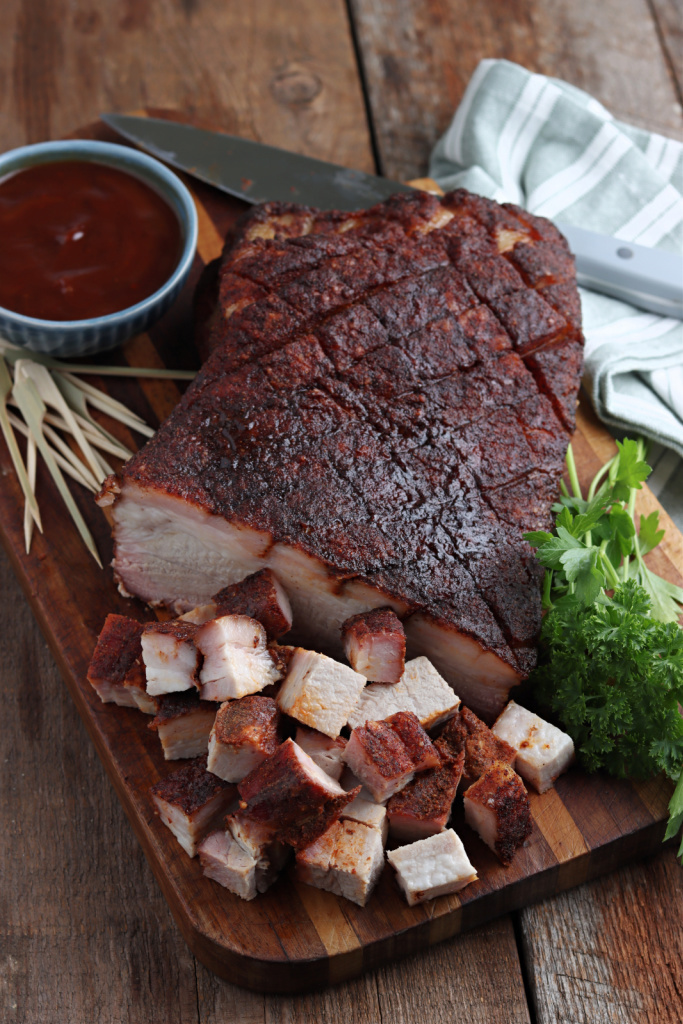 Smoked Pork Belly cut on cutting board with sauce