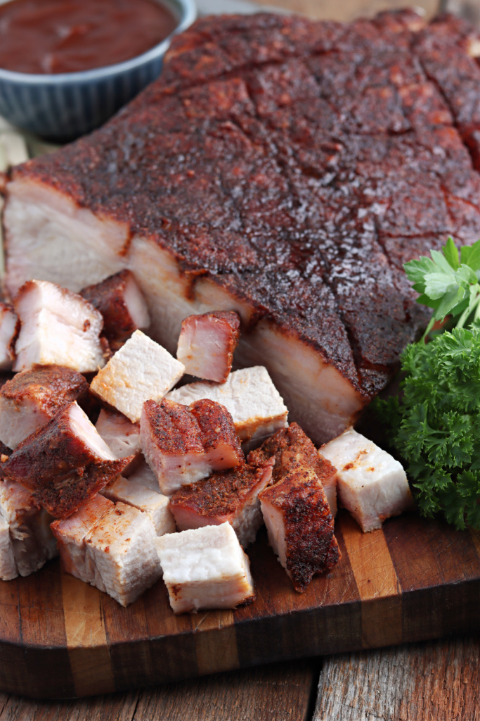 Smoked Pork Belly cut on cutting board with sauce