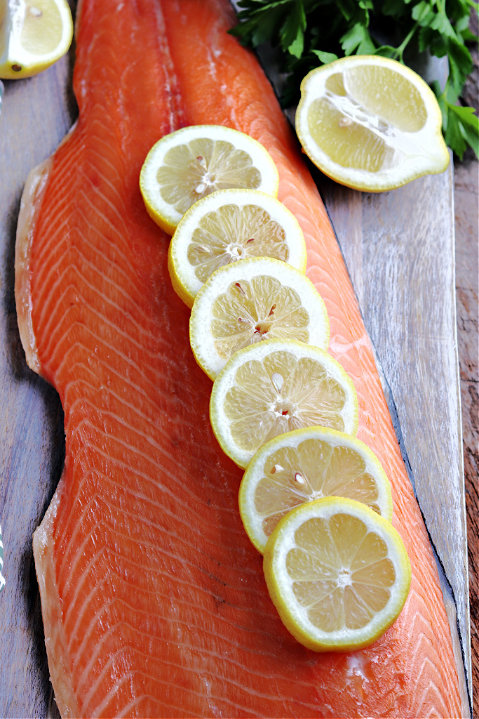 smoked salmon on cutting board with lemon and parsley