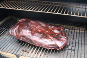 brisket wrapped in butcher paper on Traeger smoker