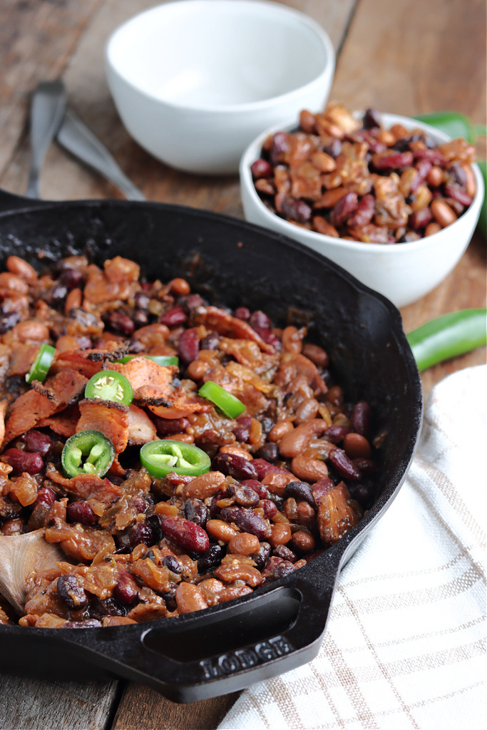 smoked baked beans in cast iron skillet and serving in bowl