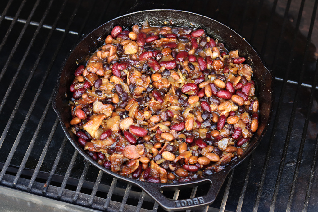 smoked baked beans cooked on Traeger in cast iron skillet