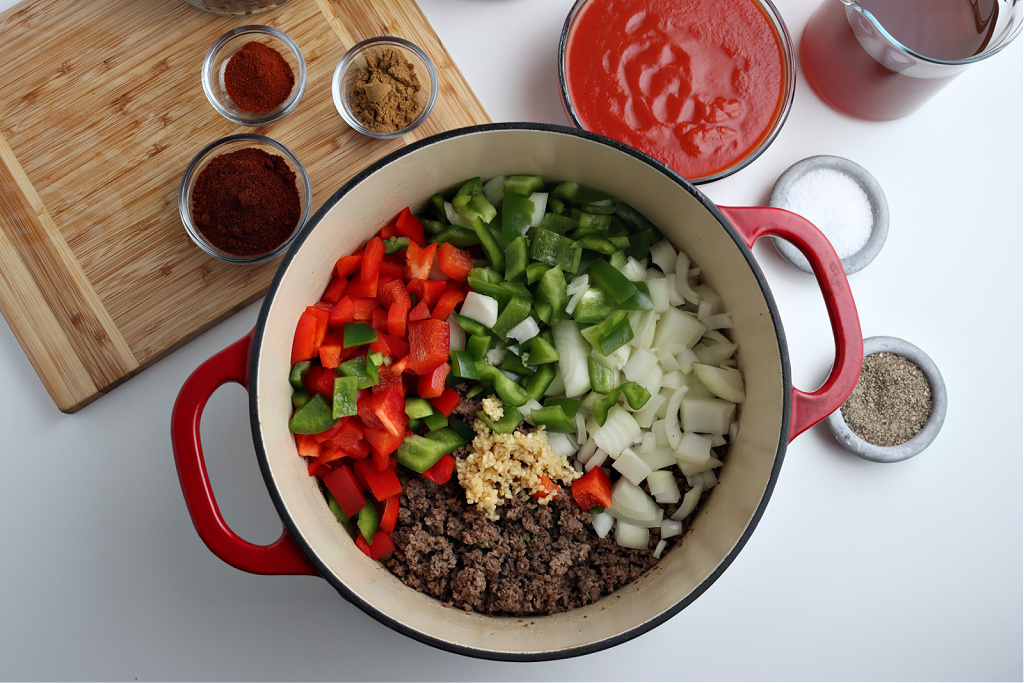 ground beef cooked in dutch oven with red and green peppers, onions and garlic